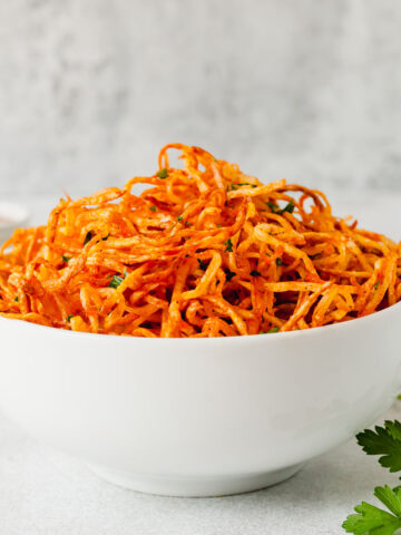 a white bowl filled with shoestring french fries