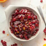 bowl of cranberry sauce with dried cranberries topped with orange zest