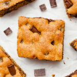 pumpkin chocolate chip bars on white parchment paper with chocolate chunks