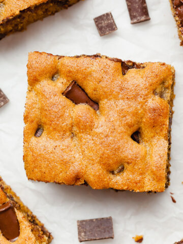 pumpkin chocolate chip bars on white parchment paper with chocolate chunks