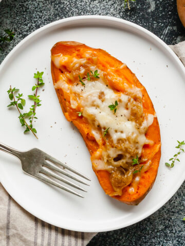 half of a twice baked sweet potato on a plate with a fork next to it