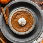 single serving crustless pumpkin pie in a small pie dish with a dollop of whipped cream on top