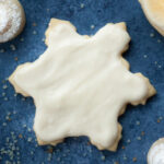 a christmas cookie cut out in the shape of a star and frosted with white frosting
