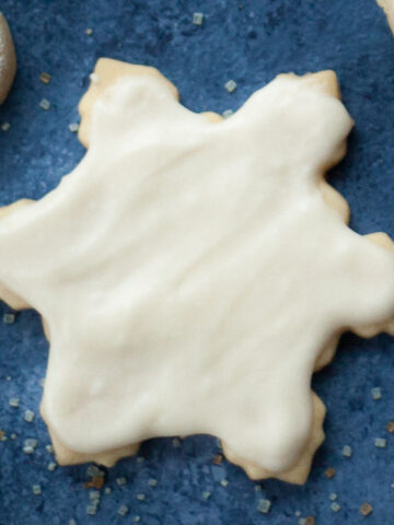 a christmas cookie cut out in the shape of a star and frosted with white frosting