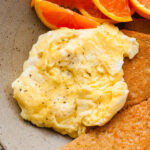 a close up of soft scrambled eggs on a plate