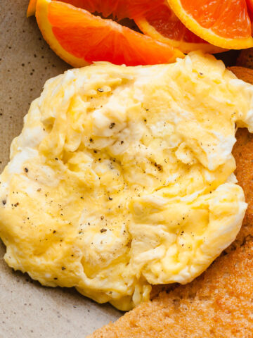a close up of soft scrambled eggs on a plate