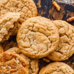 a close up of peanut butter pretzel cookies on a wood cutting board