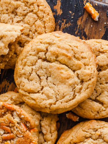 a close up of peanut butter pretzel cookies on a wood cutting board