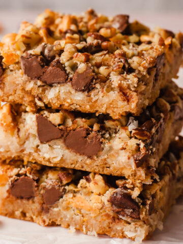 a stack of three seven layer bars on a piece of parchment