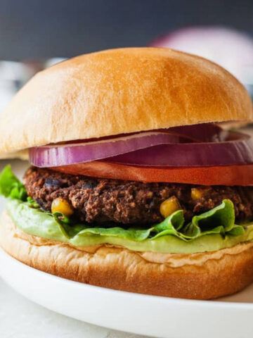 Black bean burger with avocado whip on a white plate.
