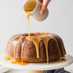 Caramel glaze being poured over brown sugar pound cake.