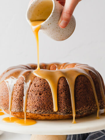 Caramel glaze being poured over brown sugar pound cake.