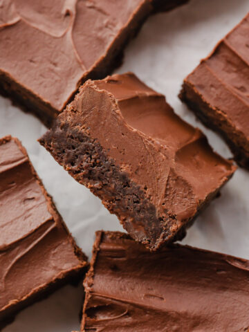 Refrigerator Bakery Brownies cut into squares on a sheet of parchment paper.