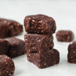A stack of three larabar mini brownie bites with a bite taken out of the top one.