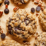 Coconut Oatmeal Chocolate Chip Cookies surrounded by pecans and chocolate chips.