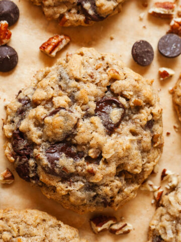 Coconut Oatmeal Chocolate Chip Cookies surrounded by pecans and chocolate chips.