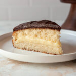 A slice of Boston cream pie on a plate.