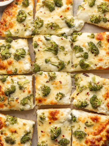 Alfredo pizza topped with broccoli cut into squares.
