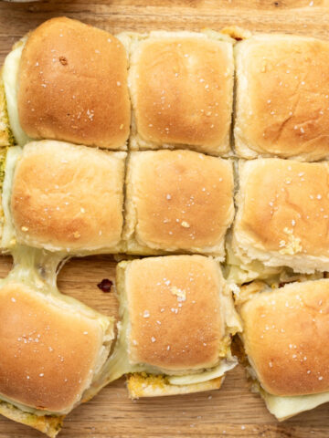 9 vegetarian cheese sliders on a cutting board.