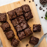 Zucchini brownies cut in squares on a cutting board.