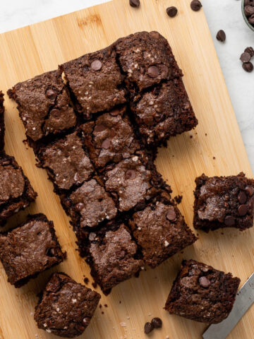 Zucchini brownies cut in squares on a cutting board.