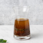 Vegan kabob marinade in a small glass carafe.