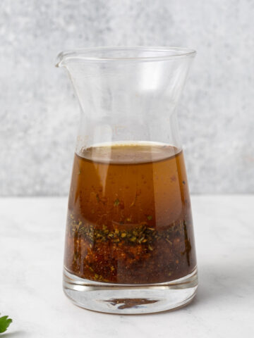 Vegan kabob marinade in a small glass carafe.