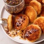 A plate of fried goat cheese bites drizzled with hot honey.
