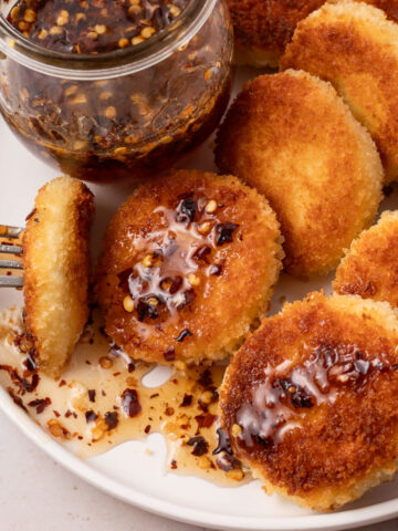 A plate of fried goat cheese bites drizzled with hot honey.