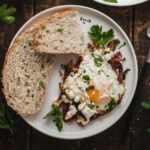 Mediterranean Eggs and slices of toast on a plate next to a fork.