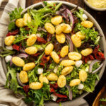 A big bowl of salad with air fryer gnocchi on top.