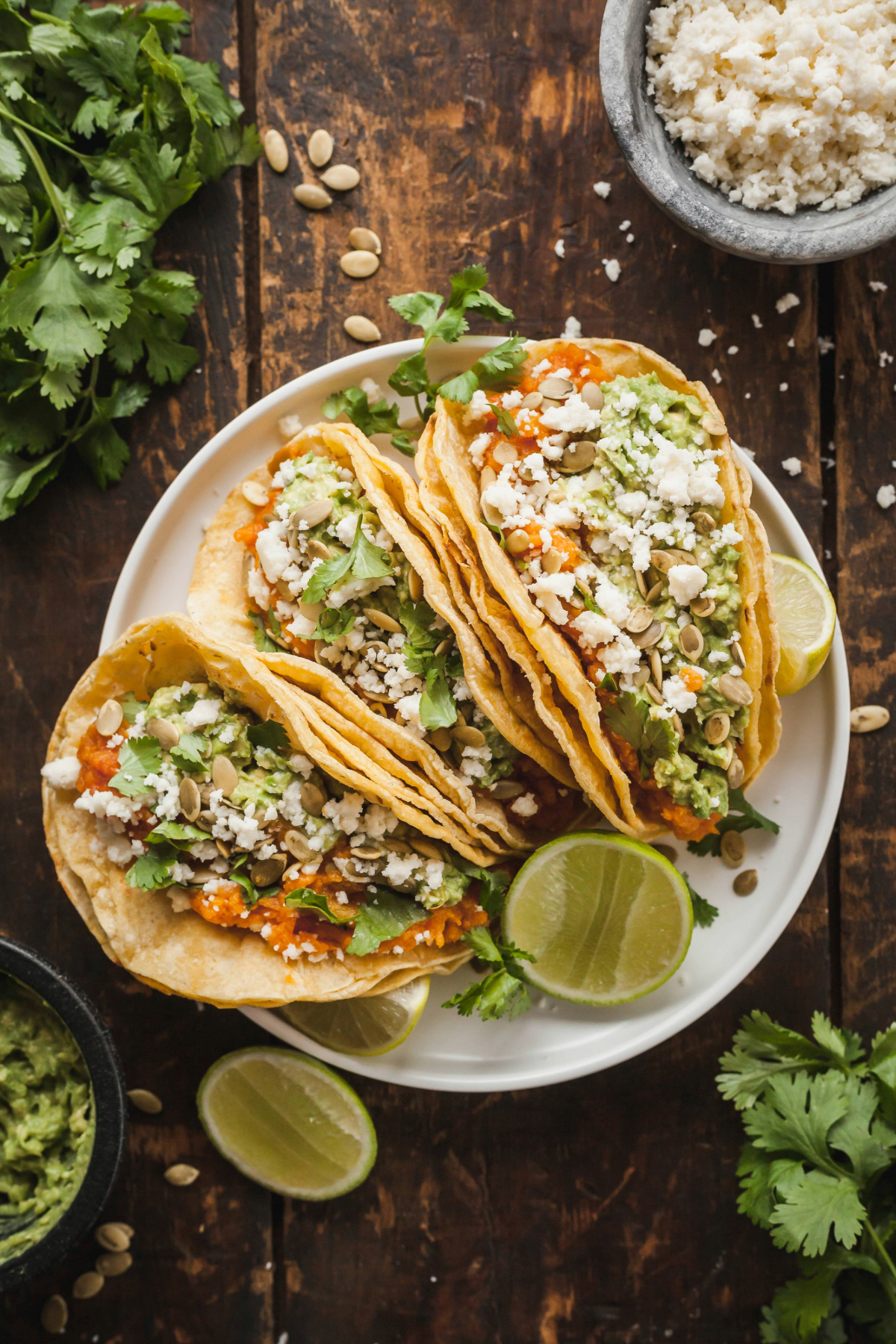 Three mashed sweet potato tacos on a white plate. 