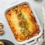 Baked giardiniera dip in white casseroled dish.