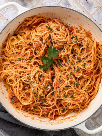 A large white pot of Spaghetti alla Ceci topped with fresh parsley.