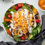 Salad Bar Salad topped with cheddar cheese and a drizzle of ranch dressing.