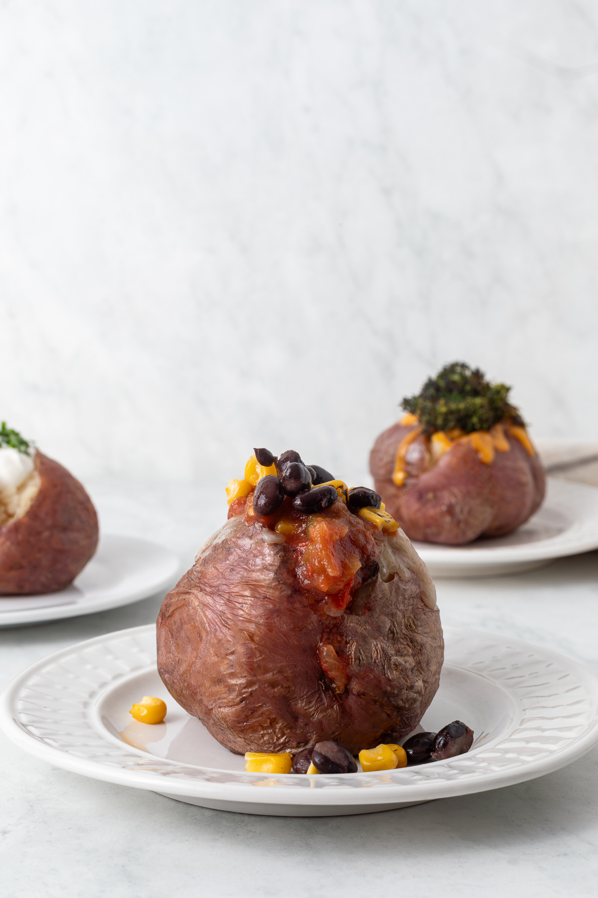 Red baked potato topped with salsa, black beans, and corn.