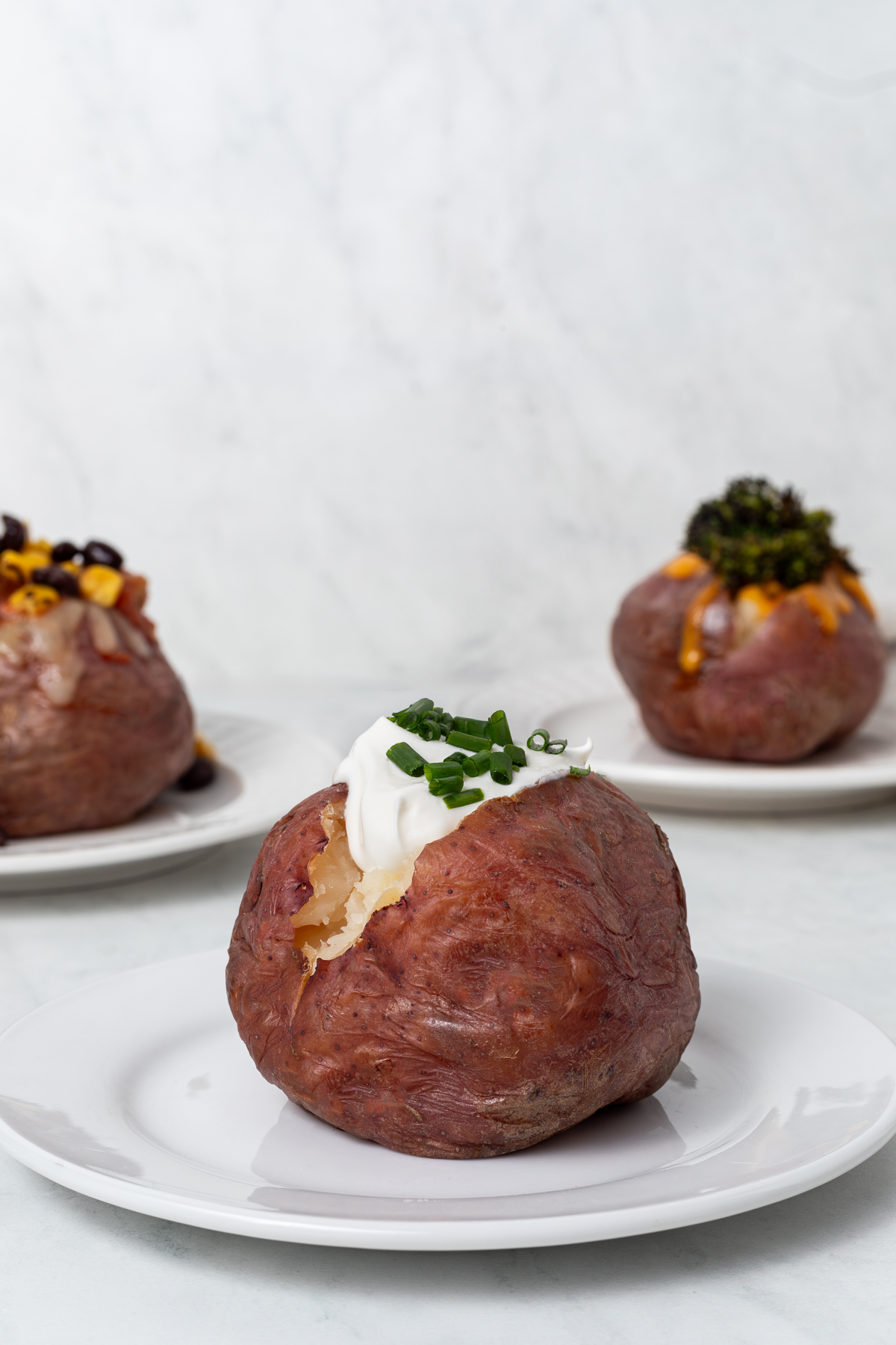 Red baked potato topped with sour cream and chives.