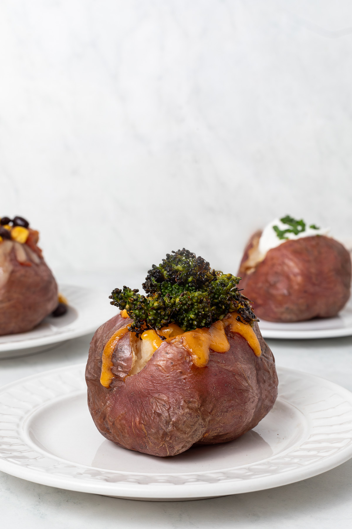 Red baked potato topped with cheddar cheese and roasted broccoli.