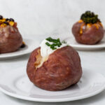Red baked potato topped with sour cream and chives.