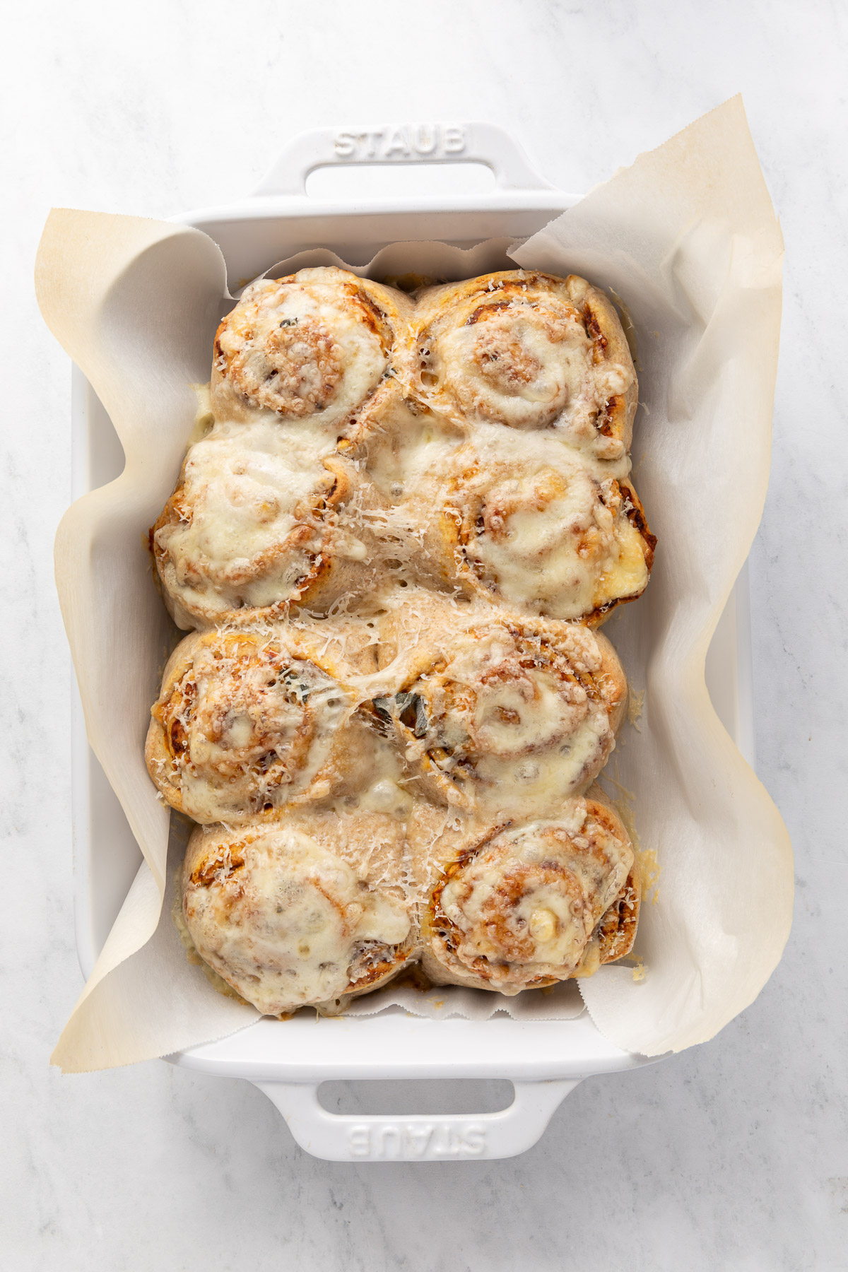 Baked butternut squash rolls in a baking dish.