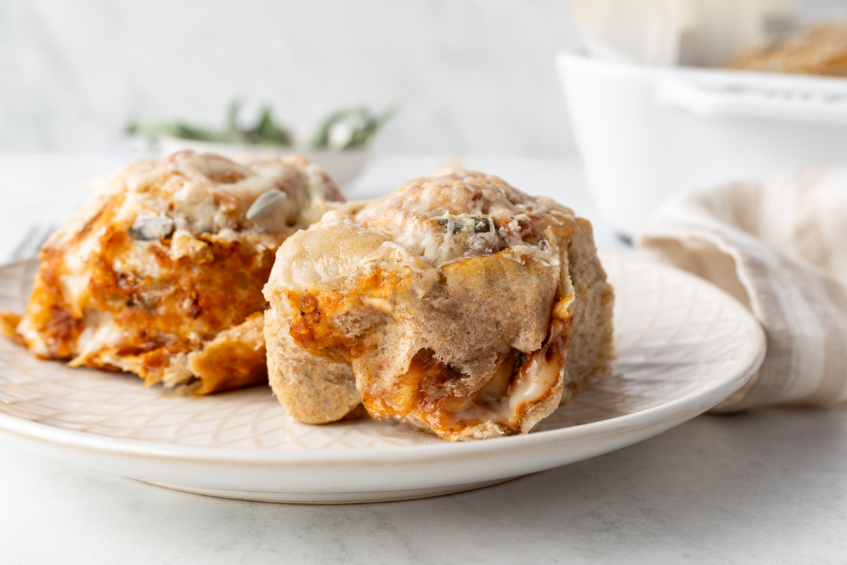 Two butternut squash rolls on a white plate.