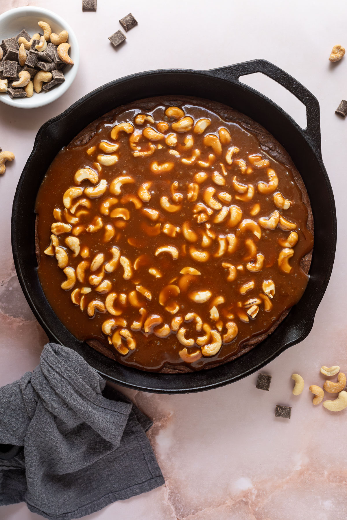Brownie baked in a cast iron skillet topped with cashew caramel.