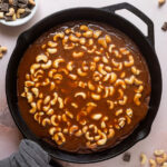 Brownie baked in a cast iron skillet topped with cashew caramel.
