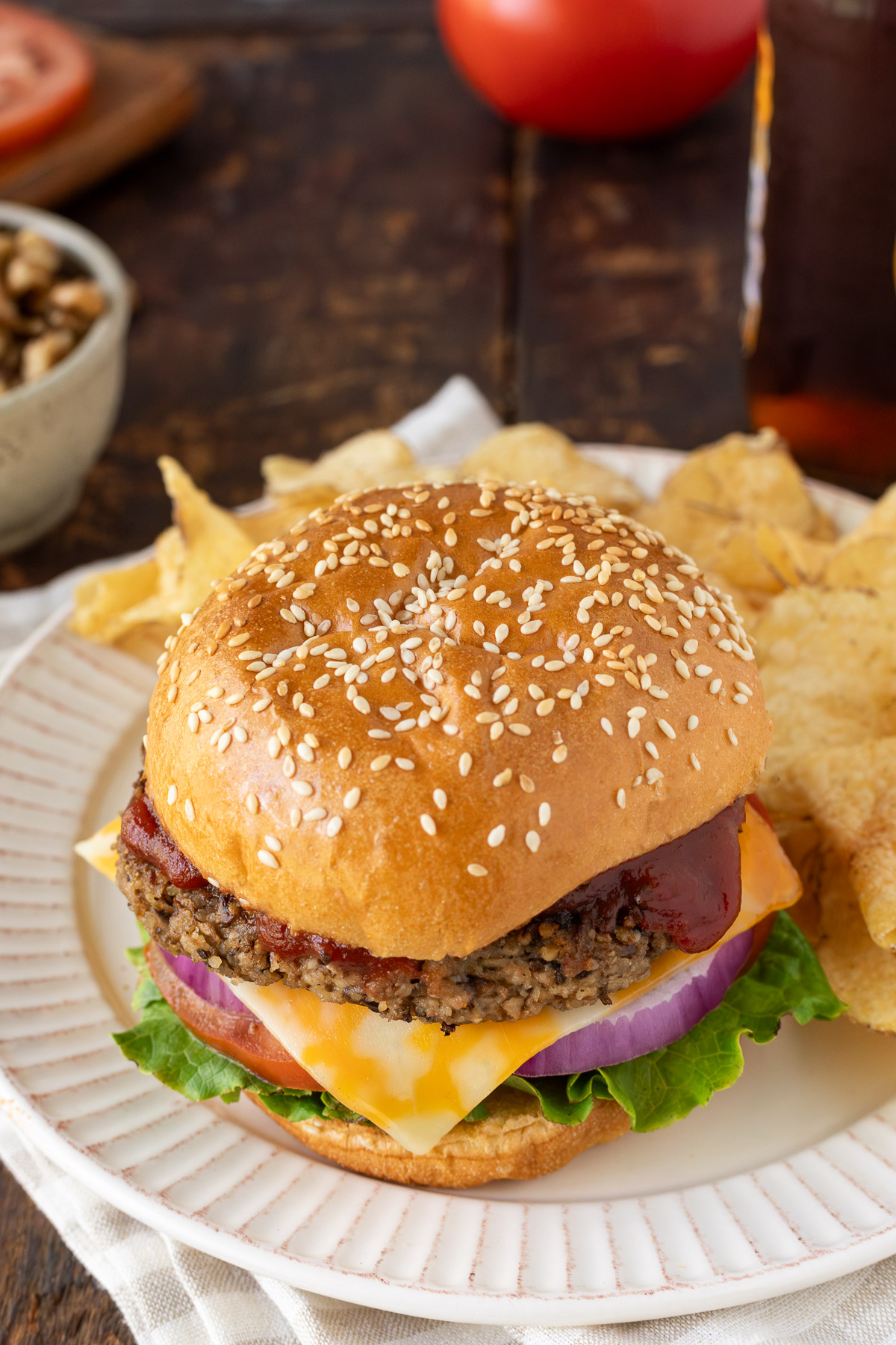A walnut burger on a plate with a side of potato chips.