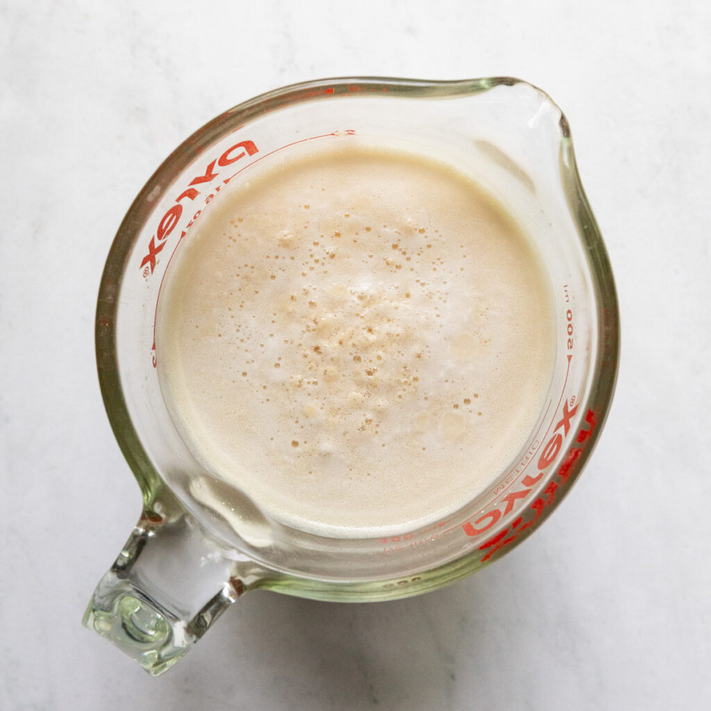 Yeast mixture in a measuring cup.