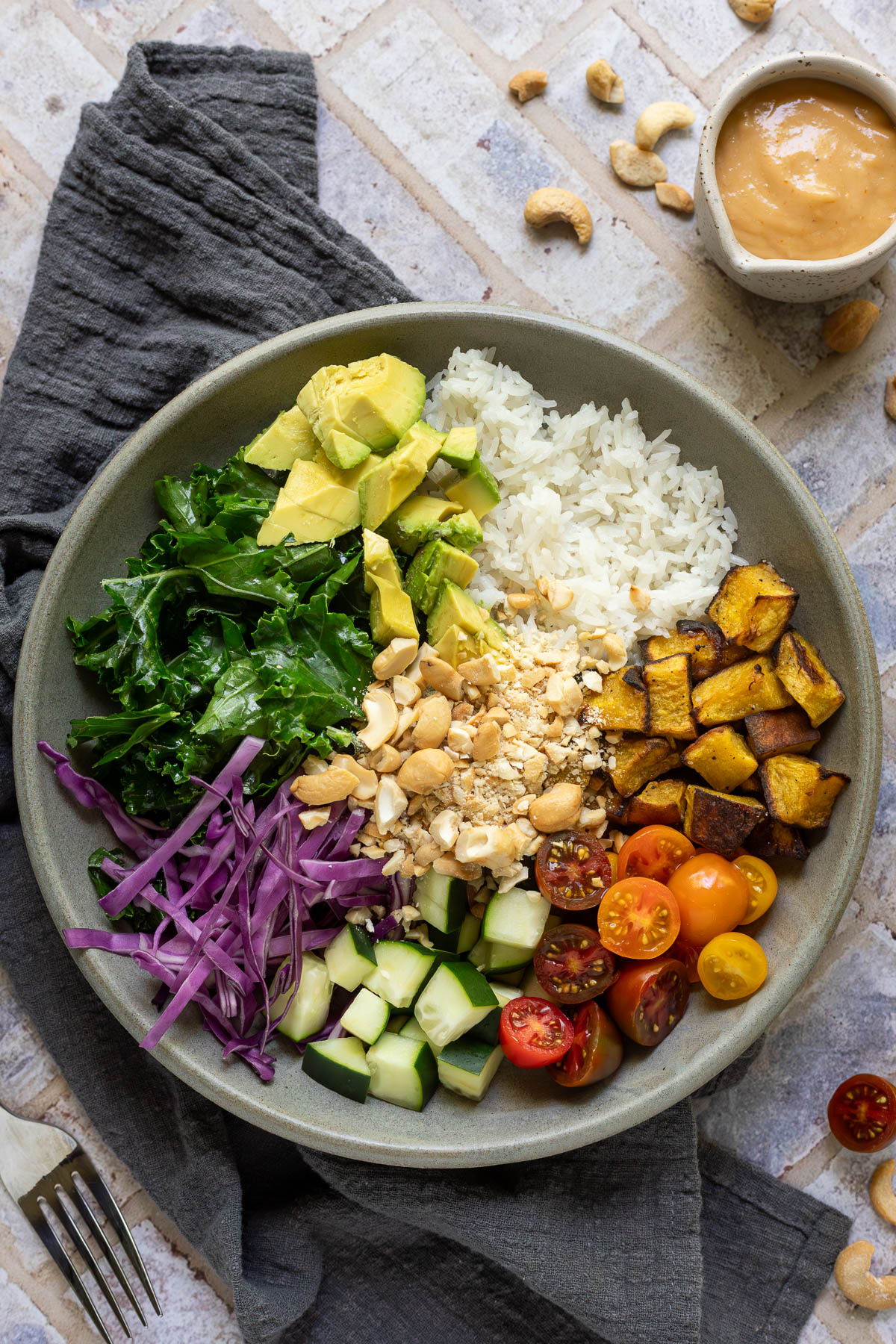 Cashew rice bowl with a small cup of dressing to the side.