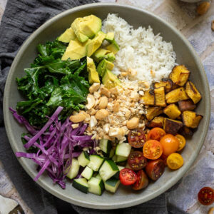 Cashew rice bowl with a small cup of dressing to the side.