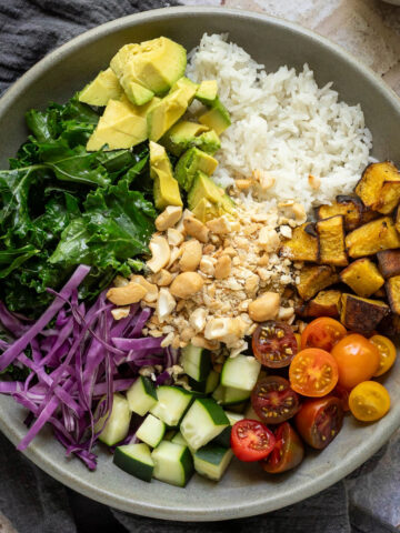 Cashew rice bowl with a small cup of dressing to the side.