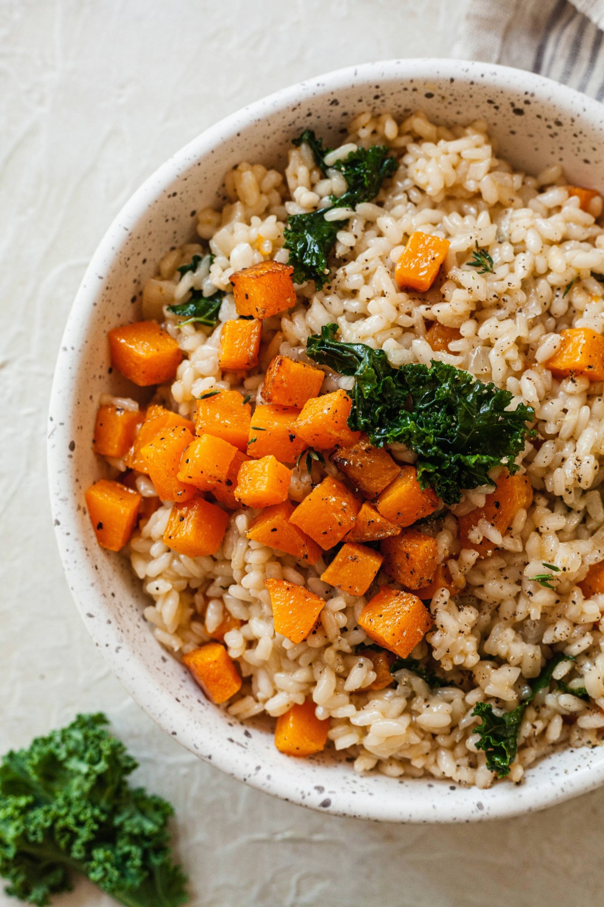 Close up on a bowl of risotto with butternut squash and kale.