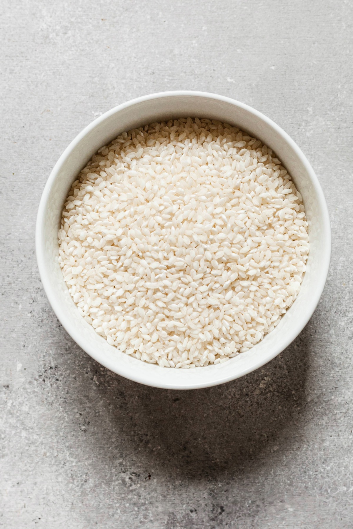 A bowl of uncooked arborio rice.